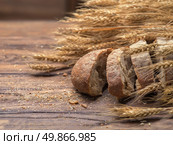 Bread and wheat on wooden table, shallow DOF, raw image. Стоковое фото, агентство Ingram Publishing / Фотобанк Лори