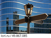 Blank signpost with ancient lamp against business building. Стоковое фото, агентство Ingram Publishing / Фотобанк Лори