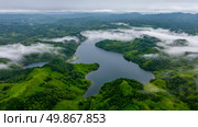 Scenic aerial overlook of mountainous region with a tranquil lake partially obscured by fog. Стоковое AI-изображение, AI-художник Данила Большаков / Фотобанк Лори