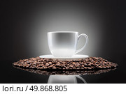white cup with coffee beans on black. Стоковое фото, агентство Ingram Publishing / Фотобанк Лори