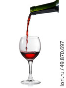 Pouring red wine in glass goblet isolated on white. Стоковое фото, агентство Ingram Publishing / Фотобанк Лори