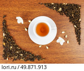 white cup and saucer with jasmine flowers on a wooden table. view from above. Стоковое фото, агентство Ingram Publishing / Фотобанк Лори