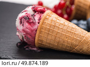 Ice cream cone with scoop of red fruits on dark textured background. Стоковое фото, агентство Ingram Publishing / Фотобанк Лори