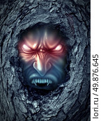 Vampire zombie ghost with glowing evil eyes living inside a dark old haunted tree trunk as a halloween symbol of bad horror spirits haunting the living world as a monster demon looking for blood. Стоковое фото, агентство Ingram Publishing / Фотобанк Лори