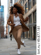 A woman in a brown suit running down a city street. Стоковое AI-изображение, AI-художник Данила Большаков / Фотобанк Лори