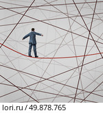 Focused On Strategy with a businessman as a high wire tight rope walker confronting adversity with a web of confused tangled group of wires trying to distract from the planned business goal for success. Стоковое фото, агентство Ingram Publishing / Фотобанк Лори