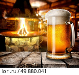 Mug of foamy beer on wooden table in bar. Стоковое фото, агентство Ingram Publishing / Фотобанк Лори