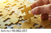 A person holding a piece of a puzzle, examining it closely. Стоковое AI-изображение, AI-художник Данила Большаков / Фотобанк Лори