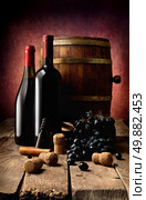 Bottles of wine, corks, corkscrew and wooden cask on table. Стоковое фото, агентство Ingram Publishing / Фотобанк Лори