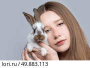 A teenage girl with blond hair holds a pockmarked rabbit. Стоковое фото, фотограф Лазаренко Светлана / Фотобанк Лори
