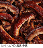 Ribs grilled barbecue meat with a close up view of a group of delicious cooked marinated spare rib as  gourmet food for dinner at a restaurant or backyard BBQ grill. Стоковое фото, агентство Ingram Publishing / Фотобанк Лори