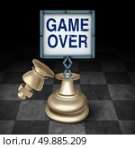 Game over business concept as an open king chess piece on a checkered board with a sign emerging with words representing the competitive metaphor and symbol for the end or termination as a winner or loser. Стоковое фото, агентство Ingram Publishing / Фотобанк Лори