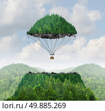 Imagination concept as a person lifting off with a detached top of a mountain floating up to the sky as a hot air balloon as a metaphor for the power of imagining traveling and dreaming of moving mountains. Стоковое фото, агентство Ingram Publishing / Фотобанк Лори