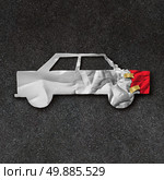 Car repair accident symbol and automobile crash fix concept on an asphalt road with  white crumpled paper shaped as a damaged and dented auto as an icon of insurance and transportation safety issues and bodyshop mechanic repairing. Стоковое фото, агентство Ingram Publishing / Фотобанк Лори