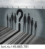 Immigration crisis as foreign people on a border wall for a social issue about refugees or illegal immigrants with the cast shadow of a group of migrating women men and children with a question mark as a symbol of confusion and risk. Стоковое фото, агентство Ingram Publishing / Фотобанк Лори