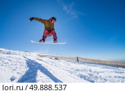 Snowboarder executing a radical jump against blue sky. Стоковое фото, агентство Ingram Publishing / Фотобанк Лори