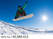 Snowboarder executing a radical jump against blue sky. Стоковое фото, агентство Ingram Publishing / Фотобанк Лори