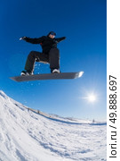 Snowboarder executing a radical jump against blue sky. Стоковое фото, агентство Ingram Publishing / Фотобанк Лори