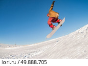 Snowboarder executing a radical jump against blue sky. Стоковое фото, агентство Ingram Publishing / Фотобанк Лори