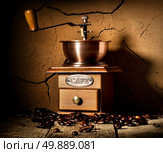 Wooden coffee mill and grains of coffee near clay wall. Стоковое фото, агентство Ingram Publishing / Фотобанк Лори