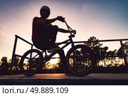 Bmx rider and his bike silhouette against sky at sunset. Стоковое фото, агентство Ingram Publishing / Фотобанк Лори