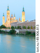 Our Lady of the Pillar Basilica with Ebro River at dusk Zaragoza, Spain. Стоковое фото, агентство Ingram Publishing / Фотобанк Лори