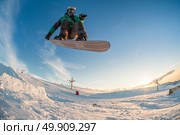Snowboarder executing a radical jump against sunset sky. Стоковое фото, агентство Ingram Publishing / Фотобанк Лори