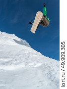 Snowboarder executing a radical jump against blue sky. Стоковое фото, агентство Ingram Publishing / Фотобанк Лори