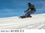 Snowboard freerider in the mountains against in blue sky. Стоковое фото, агентство Ingram Publishing / Фотобанк Лори