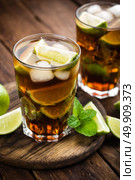 Cuba Libre cocktail with cola, lime and ice in glass, cold longdrink. Стоковое фото, агентство Ingram Publishing / Фотобанк Лори