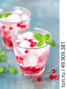 Infused water made of fresh pomegranate and mineral water with ice, cold refreshing and detox drink. Стоковое фото, агентство Ingram Publishing / Фотобанк Лори