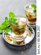 Mint Julep cocktail with bourbon, ice and mint in glass on black background. Стоковое фото, агентство Ingram Publishing / Фотобанк Лори