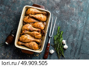Grilled fried roast chicken legs, drumsticks on dark background, meat with ingredients for cooking, top view. Стоковое фото, агентство Ingram Publishing / Фотобанк Лори