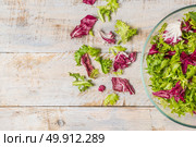 Fresh lettuce leafs mix salad in glass bowl on wooden table. Стоковое фото, агентство Ingram Publishing / Фотобанк Лори