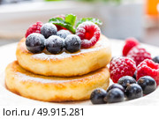 Cottage cheese pancakes, syrniki, curd fritters with berries. Стоковое фото, агентство Ingram Publishing / Фотобанк Лори