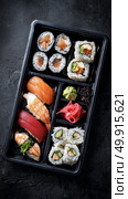 Delicious Sushi Bento Box With Fresh Ingredients Served on Wooden Table. Стоковое AI-изображение, AI-художник Юлия Гапеенко / Фотобанк Лори