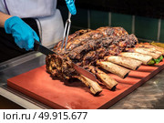 Chef Carving prime rib of  roast Wagyu beef . Стоковое фото, агентство Ingram Publishing / Фотобанк Лори