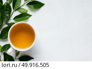 Sip of Warm Tea With Fresh Leaves on a Clean Surface in Natural Light During Morning Relaxation. Стоковое AI-изображение, AI-художник Юлия Гапеенко / Фотобанк Лори