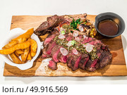 Grain fed Grilled Tomahawk Beef steak with fried potato wedge. Стоковое фото, агентство Ingram Publishing / Фотобанк Лори