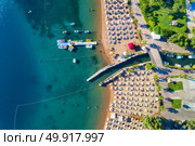 Aerial view of transparent turquoise sea, beautiful sandy beach with colorful chaise-lounges, boats, green trees, hotels, buildings at sunset in Icmeler,Turkey. Summer seascape Top view from drone. Aerial view of transparent turquoise sea. Стоковое фото, агентство Ingram Publishing / Фотобанк Лори
