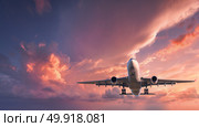 Landing airplane. Landscape with white passenger airplane is flying in the red sky with colorful clouds at sunset. Travel background. Passenger airliner. Business trip. Commercial aircraft.Private jet. Стоковое фото, агентство Ingram Publishing / Фотобанк Лори