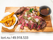Grain fed Grilled Tomahawk Beef steak with fried potato wedge. Стоковое фото, агентство Ingram Publishing / Фотобанк Лори