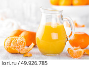 Tangerines, peeled tangerines and tangerine juice in glass. Mandarine juice. Стоковое фото, агентство Ingram Publishing / Фотобанк Лори