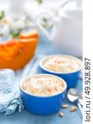 Cooking on kitchen table delicious mini casserole with cottage cheese and pumpkin for breakfast. White background. Стоковое фото, агентство Ingram Publishing / Фотобанк Лори