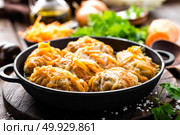 Cabbage rolls stewed with meat and vegetables in pan on dark wooden background. Стоковое фото, агентство Ingram Publishing / Фотобанк Лори