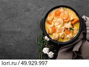Meat stew, chicken fillet in sauce with carrot in a cast iron pot, top view. Стоковое фото, агентство Ingram Publishing / Фотобанк Лори