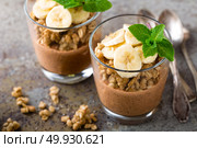 Layered chocolate chia pudding parfait with banana, granola and yogurt, dessert. Стоковое фото, агентство Ingram Publishing / Фотобанк Лори