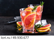 Grapefruit and fresh rosemary gin cocktail with juice, cold summer citrus refreshing drink or beverage with ice. Стоковое фото, агентство Ingram Publishing / Фотобанк Лори