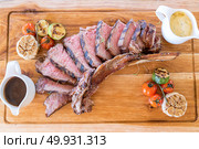 Grilled tomahawk steak on wooden plate. Стоковое фото, агентство Ingram Publishing / Фотобанк Лори