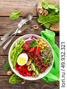 Buddha bowl dish with boiled egg, chickpea, fresh tomato, sweet pepper, cucumber, savoy cabbage, red onion, green sprouts, spinach leaves, walnuts, chia and rice. Healthy lunch, dinner. Detox diet. Стоковое фото, агентство Ingram Publishing / Фотобанк Лори